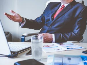 Manager sitting behind a desk giving direction to staff