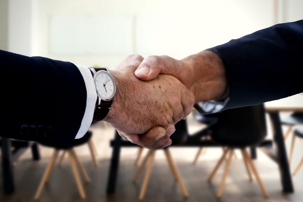 two men shaking hands, potentially as some kind of business deal