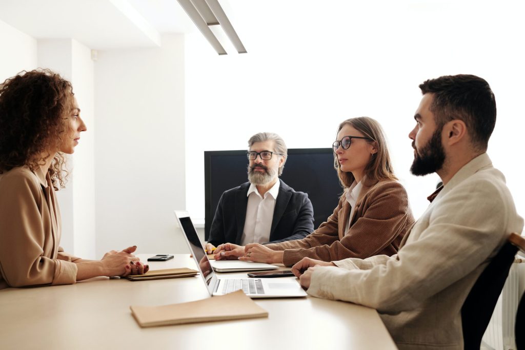 Individuals sat around a table in a formal meeting.